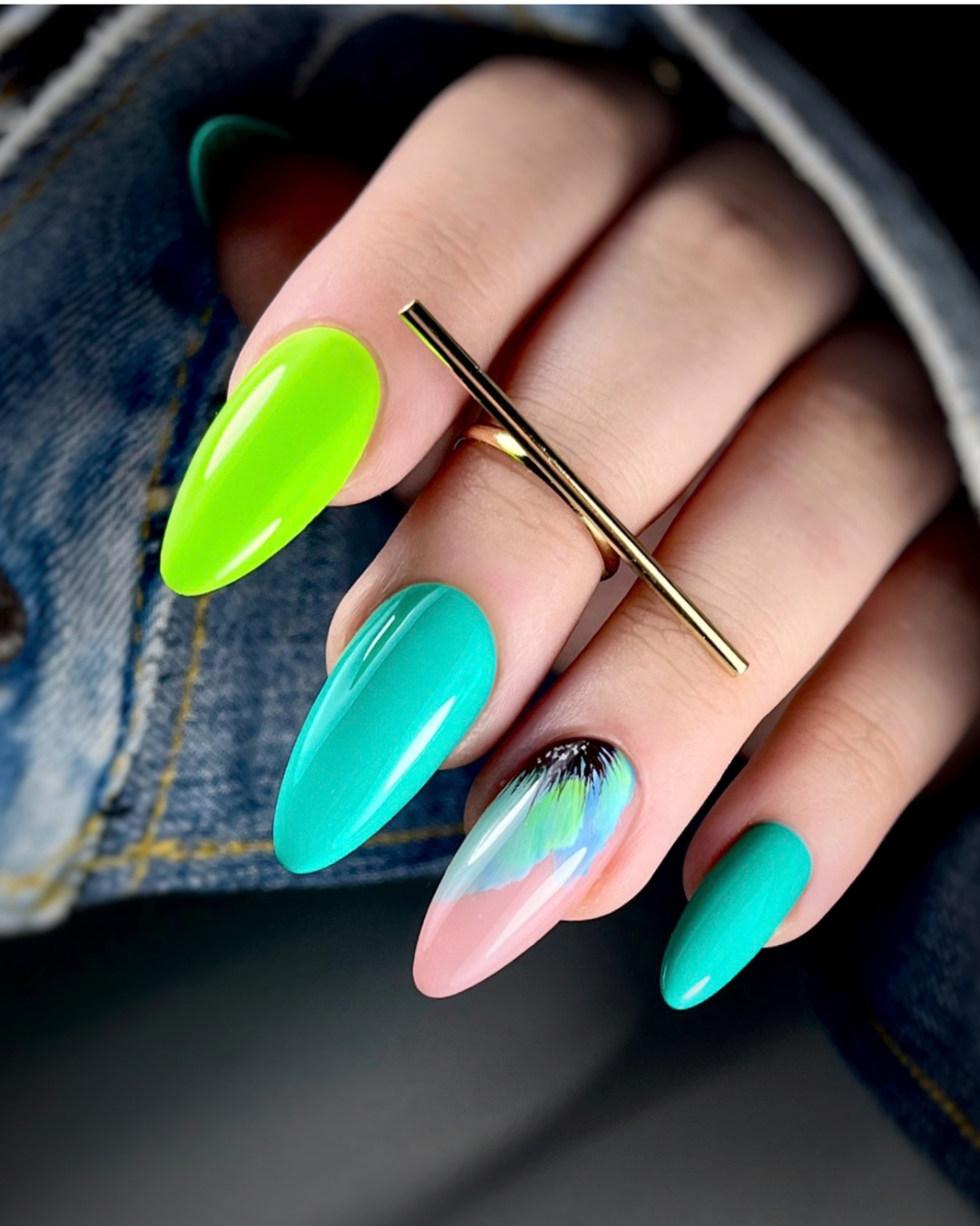 A close-up of a hand with long almond-shaped nails painted in bright neon green, turquoise, pastel pink with iridescent rainbow swirls, and turquoise. Featuring  Phenomenail™ M.E.T.A Pro PIGM-A Gel Polish In Levi. 
