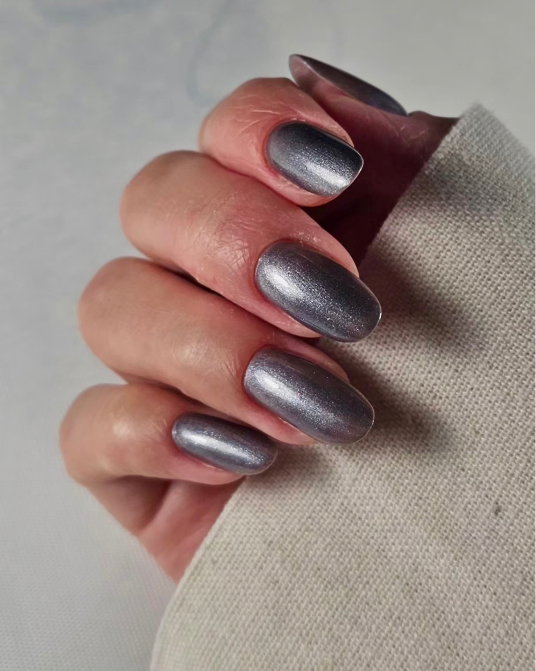 Close-up of a gunmetal manicure with a brushed-metal pearl finish created using Gunmetal professional gel polish.